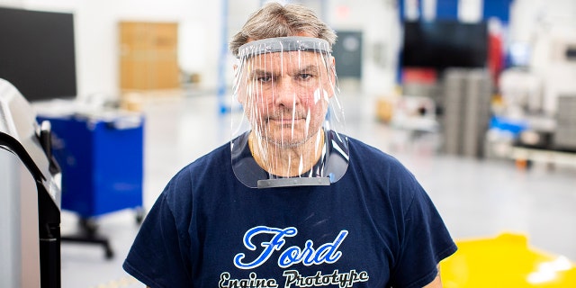 Dave Jacek, 3D printing technical, wears a prototype of a 3D-printed medical face shield printed at Ford’s Advanced Manufacturing Center. 