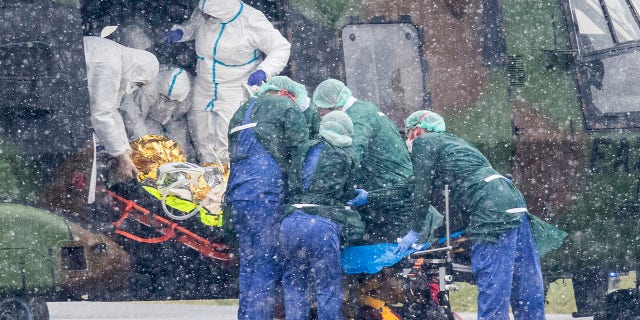A coronavirus patient from Metz in France is transported from a military helicopter for treatment at the University Hospital in Essen, Germany. (Marcel Kusch/dpa via AP)