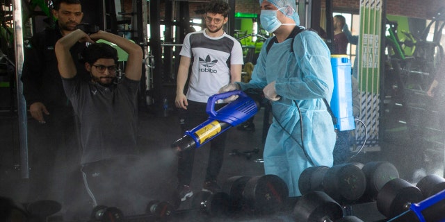 In this Sunday, March 15, 2020 file photo, a Palestinian health worker sprays disinfectant as a precaution against the coronavirus in a gymnasium in Gaza City.