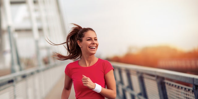 A young woman runs on a bridge.