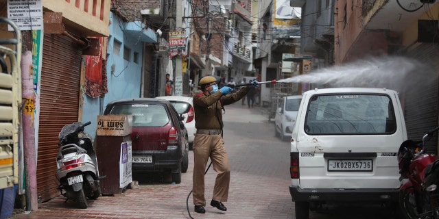 A fire brigade person disinfects an area during lockdown to prevent the spread of new coronavirus in Jammu, India, Tuesday, March 31, 2020.