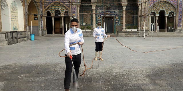 Iranian workers disinfect the shrine of the Shiite Saint Imam Abdulazim to help prevent the spread of the new coronavirus in Shahr-e-Ray, located south of Tehran, on Saturday. (AP Photo/Ebrahim Noroozi)
