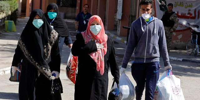 Iraqi women who have recovered from the coronavirus wear protective face masks as they leave the quarantine hospital, following the outbreak of the virus, in Baghdad, Iraq March 9. REUTERS/Khalid al-Mousily