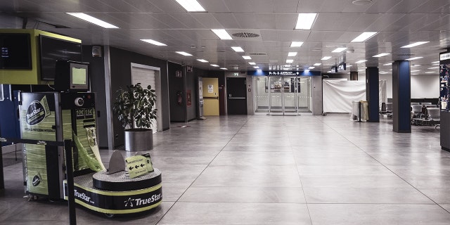 A luggage wrapping machine stands in an empty departure hall at Linate airport in Milan, Italy, on Feb. 26.