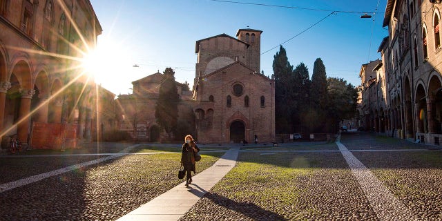 A woman walks past the Basilica of Santo Stefano, in Bologna on Wednesday following a country-wide lockdown. (Massimo Paolone/LaPresse via AP)