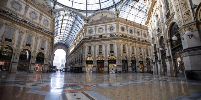 The Vittorio Emanuele shopping arcade appeared almost desert in Milan on Wednesday as Italy mulls even tighter restrictions on daily life. (AP Photo/Luca Bruno)