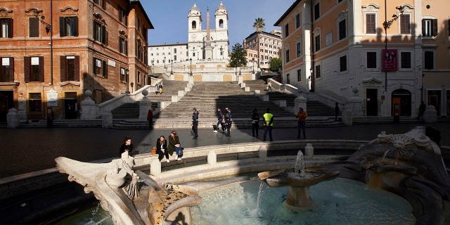 Two people sit by the Barcaccia fountain near almost empty Spanish Steps, in Rome on Tuesday. (AP Photo/Andrew Medichini)