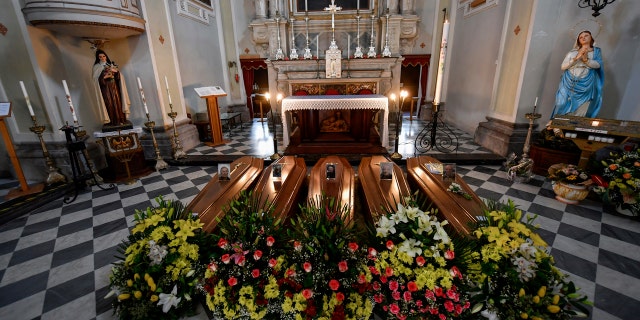 Coffins wait to be transported to cemetery, in the church of Serina, near Bergamo, Northern Italy, Saturday, March 21, 2020.
