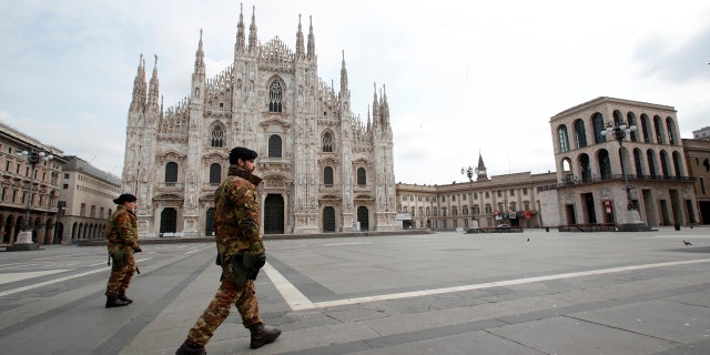 Italian soldiers patrol the square facing Duomo gothic cathedral in downtown Milan, Italy, Sunday, March 22, 2020. Italian Premier Giuseppe Conte has told the nation he is tightening the lockdown to fight the rampaging spread of coronavirus, shutting down all production facilities except those that are "necessary, crucial, indispensable to guarantee" the good of the country. (AP Photo/Antonio Calanni)