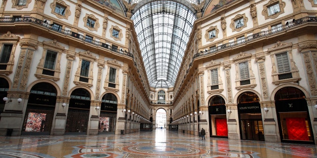 A man walks in an empty Vittorio Emanuele II gallery shopping arcade, in downtown Milan, Italy, Sunday, March 22, 2020.