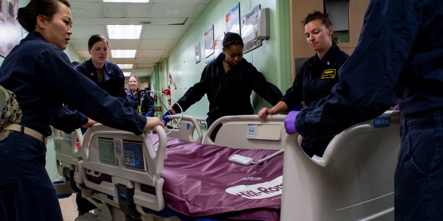 Sailors assigned to the USNS Mercy relocate patient beds after the ship was deployed support of the nation's COVID-19 response efforts, and will serve as a referral hospital for non-COVID-19 patients currently admitted to shore-based hospitals in Los Angeles.