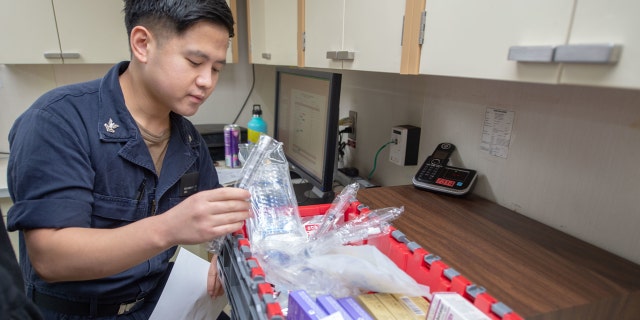 Hospital Corpsman 2nd Class Benjamin Ong, from Bremerton, Wash., assembles emergency medicine carts aboard the hospital ship USNS Mercy on Wedneday. Mercy deployed in support of the nation's COVID-19 response efforts.