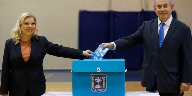 Netanyahu and his wife Sara cast their ballots during the Israeli legislative elections at a polling station in Jerusalem on Monday. (Atef Safadi/Pool Photo via AP)
