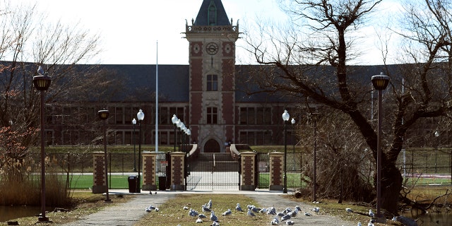 This photo shows the front gate of the New Rochelle High School, situated inside what's called a "containment area," Wednesday, March 11, 2020 in New Rochelle, N.Y. The school is among the nine closed as a precaution to contain the virus' spread. State officials on Tuesday called for closing schools, houses of worship and any other spaces were large numbers of people gather within a 1-mile radius of a point near a synagogue where an infected person had attended events.