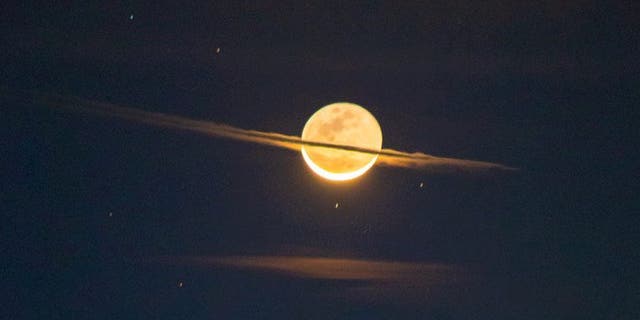 This stunning image has captured a new perspective of the Moon - making it appear like its distant neighbor Saturn. (Credit: Photographer Francisco Sojuel, SWNS)