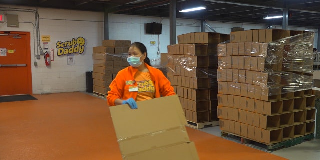 Scrub Daddy employees are spaced out six feet apart, wearing masks and gloves.