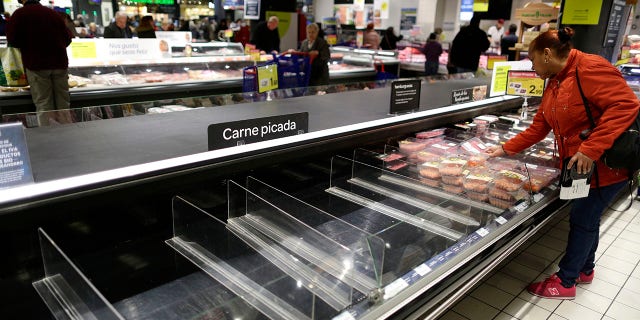 Empty shelves are seen in a supermarket as people begin to stock up on provisions in Madrid on Tuesday. (AP Photo/Manu Fernandez)