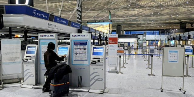 A single passenger is pictured using a check-in kiosk for Korean Air at Tokyo Narita airport, Japan, on March 2.
