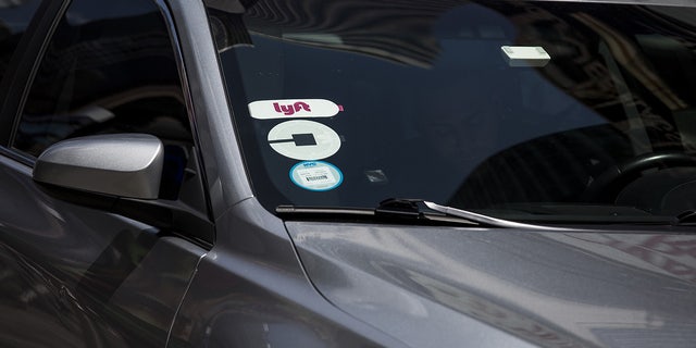 Lyft and Uber logos are seen on the windshield of a vehicle in New York on Aug. 9, 2018. (John Taggart/Bloomberg via Getty Images)