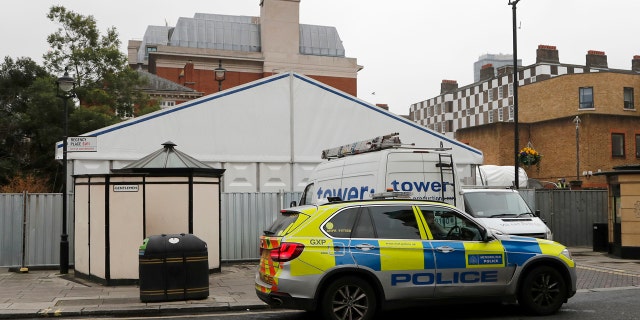 A police car in front of a tent being built to be used as a temporary morgue in London, Thursday, March 19, 2020.