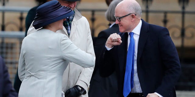 United States Ambassador to the United Kingdom Woody Johnson, right, greets by bumping elbows as he arrives to attend the annual Commonwealth Day service at Westminster Abbey in London on Monday. (AP Photo/Frank Augstein)