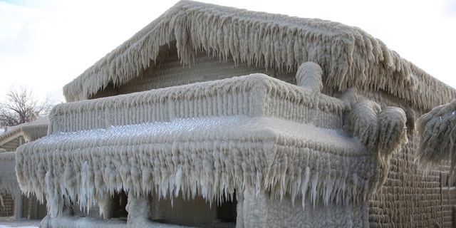 Houses along Hoover Beach is covered by ice from high winds and from the waves from Lake Erie, Saturday, Feb. 29, 2020, in Hamburg N.Y.