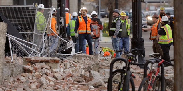 Construction workers looks at the rubble from a building after an earthquake Wednesday, March 18, 2020, in Salt Lake City.