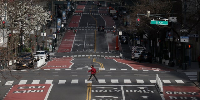 NEW YORK, NY - MARCH 22: A person walks across 42nd Street on March 22, 2020 in New York City. The "New York State on PAUSE" executive order, a 10-point policy to assure uniform safety for everyone goes onto effect at 8pm on Sunday. (Photo by Gary Hershorn/Getty Images)