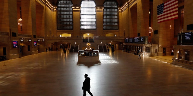 A train conductor walks through the virtually empty Grand Central Terminal on March 22, 2020, in New York City. (Photo by Gary Hershorn/Getty Images)