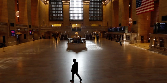 A train conductor walks through the virtually empty Grand Central Terminal on March 22, 2020, in New York City. (Photo by Gary Hershorn/Getty Images)