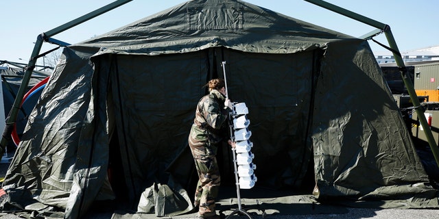 A French soldiers pulls medical gear at the military field hospital in Mulhouse on Tuesday after Macron ordered the facility built. (Mathieu Cugnot, Pool via AP)