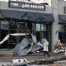 A woman walks past buildings damaged by storms in Nashville, Tenn., March 3, 2020. Tornadoes ripped across Tennessee early Tuesday, shredding buildings and killing multiple people.