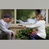 Judie Shape who has tested positive for the coronavirus blows a kiss to her son-in-law, Michael Spencer, and daughter Lori Spencer through a hospital window in Kirkland, Washington, March 11, 2020. 