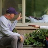 Judie Shape who has tested positive for the coronavirus blows a kiss to her son-in-law, Michael Spencer, and daughter Lori Spencer through a hospital window in Kirkland, Washington, March 11, 2020. 