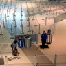 A TSA agent speaks to travelers passing through an empty security queue at Love Field airport amid concerns of the coronavirus pandemic in Dallas, Mar. 12, 2020.