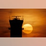 The sun sets behind the FAA Control Tower at Midway International Airport in Chicago, March 17, 2020. 