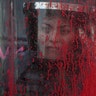 A police officer stands behind her riot shield covered in red paint during an International Women's Day march in Mexico City, March 8, 2020. 