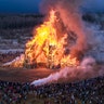 People watch as a sculpture of a bridge burns at the Maslenitsa festival at the Nikola-Lenivets art park in Nikola-Lenivets, Russia, Feb. 29, 2020. 