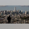A man stands in front of the skyline from Bernal Heights Hill in San Francisco, March 16, 2020. 