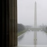 People walk in an empty Lincoln Memorial Reflecting Pool in Washington, D.C., March 25, 2020. 