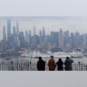 People watch as the USNS Comfort arrives in its port on the Hudson River in New York City, March 30, 2020