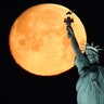 The Super Worm Moon sets behind the Statue of Liberty in New York City, March 9, 2020. 
