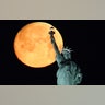 The Super Worm Moon sets behind the Statue of Liberty in New York City, March 9, 2020. 