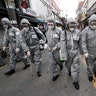 Army soldiers wearing protective suits spray disinfectant as a precaution against the coronavirus at a shopping street in Seoul, South Korea, March 4, 2020. 