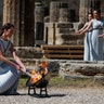 Greek actress Xanthi Georgiou, playing the role of the High Priestess, lights up the torch during the flame lighting ceremony at the Ancient Olympia site, the birthplace of the ancient Olympics in southern Greece, March 12, 2020. 