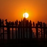 Visitors walk along the long wooden U Bein Bridge that connects the two banks of Taungthaman Lake as the sun sets in Mandalay, Myanmar, March 11, 2020.