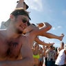 Spring break revelers party on the beach, Tuesday, March 17, 2020, in Pompano Beach, Florida. As a response to the coronavirus pandemic, Florida Gov. Ron DeSantis ordered all bars be shut down for 30 days beginning at 5 p.m. and many Florida beaches are turning away spring break crowds urging them to engage in social distancing. (AP Photo/Julio Cortez)