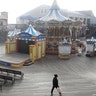 San Francisco, California: A woman walking in front of a stage and carousel at an empty Pier 39, Thursday, March 12, 2020. 