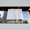 A sign posted in a restaurant window in the Chinatown-International District advises it's only offering takeout in Seattle, Wash., March 16, 2020.
