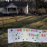 A sign showing support for residents displayed on a lawn.